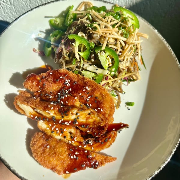 Crispy chicken with sweet sauce and sesame seeds, alongside a noodle salad with jalapeños.